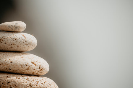 Balanced rock pyramid on sea pebbles beach, sunny day and clear sky at sunset. Golden sea bokeh on background. Selective focus, zen stones on sea beach, meditation, spa, harmony, calm, balance conceptの写真素材