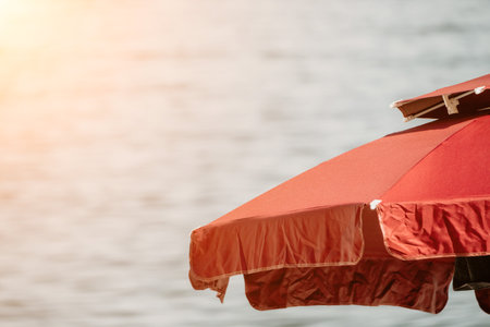 Red Beach Umbrella on the Background of the Blue Sea Ocean. Beach Landscape. Summer travel and holidays concept.の写真素材