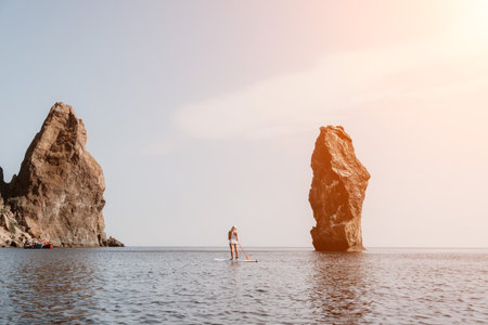 Woman sea sup. Close up portrait of happy young caucasian woman with long hair looking at camera and smiling. Cute woman portrait in bikini posing on sup board in the seaの写真素材