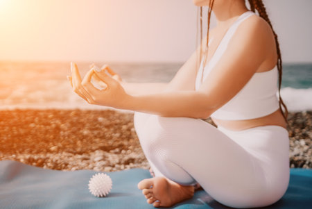 Close up Yoga Hand Gesture of Woman Doing an Outdoor meditation. Blurred sea background. Woman on yoga mat in beach meditation, mental health training or mind wellness by ocean, sea. Selective focusの写真素材