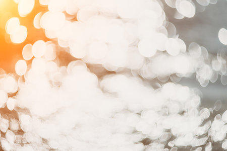 Blurred golden sea at sunset. The sun reflects and sparkles on the waves with bokeh, illuminating the golden sea. Holiday recreation concept. Abstract nautical summer ocean sunset nature background.の写真素材