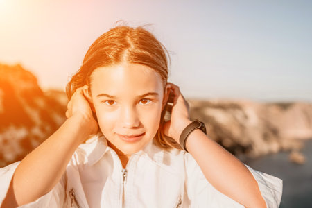 Adorable teenage girl outdoors enjoying sunset at beach on summer day. Close up portrait of smiling young romantic teenager girl with long hair on beach at summer evening. Travel and holidaysの写真素材