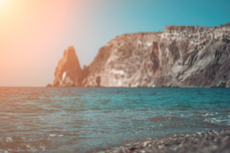 Abstract nature summer ocean sunset sea background. Small waves on water surface in motion blur with bokeh lights from sunrise. Holiday, vacation and recreational background conceptの写真素材