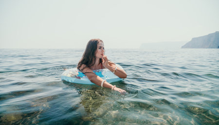 Woman summer sea. Happy woman swimming with inflatable donut on the beach in summer sunny day,...