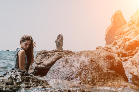 Woman summer travel sea. Happy tourist enjoy taking picture outdoors for memories. Woman traveler posing on the beach at sea surrounded by volcanic mountains, sharing travel adventure journeyの写真素材