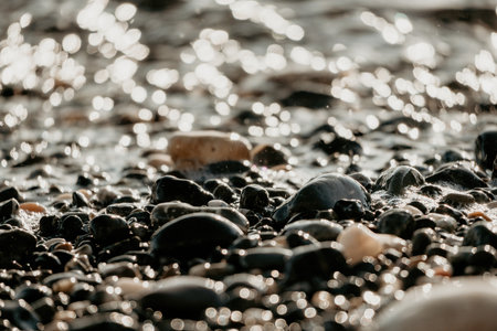 Blurred golden sea at sunset. The sun reflects and sparkles on the waves with bokeh, illuminating the golden sea. Holiday recreation concept. Abstract nautical summer ocean sunset nature background.の写真素材
