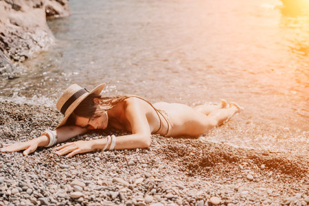 Woman travel sea. Happy tourist in hat enjoy taking picture outdoors for memories. Woman traveler posing on the beach at sea surrounded by volcanic mountains, sharing travel adventure journeyの写真素材