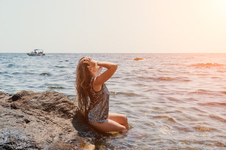 Woman summer travel sea. Happy tourist enjoy taking picture outdoors for memories. Woman traveler posing on the beach at sea surrounded by volcanic mountains, sharing travel adventure journeyの写真素材