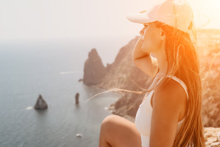 Woman summer travel sea. Happy tourist enjoy taking picture outdoors for memories. Woman traveler posing over sea bay surrounded by volcanic mountains, sharing travel adventure journeyの写真素材