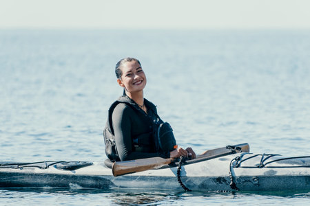 Woman sea kayak. Happy smiling woman in kayak on ocean, paddling with wooden oar. Calm sea water and...