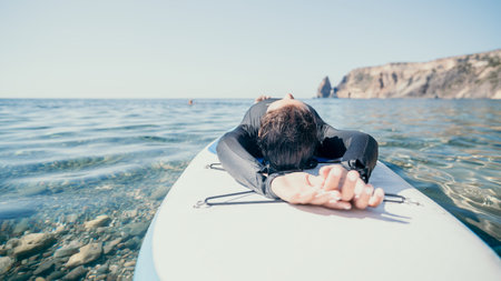 Woman sup yoga. Happy sporty woman practising yoga pilates on paddle sup surfboard. Female stretching doing workout on sea water. Modern individual female hipster outdoor summer sport activity.の写真素材