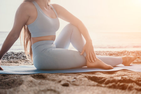 Woman sea pilates. Sporty happy middle aged woman practicing fitness on beach near sea, smiling active female training on yoga mat outside, enjoying healthy lifestyle, harmony and meditation.の写真素材