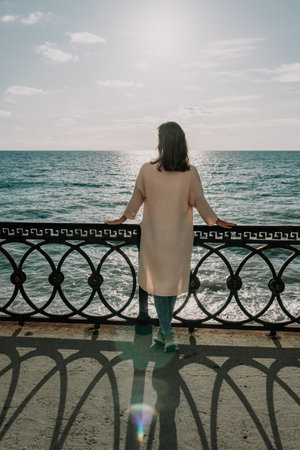 Woman summer travel sea. Happy tourist enjoy taking picture outdoors for memories. Carefree woman traveler posing on beach at sea on sunset, sharing travel adventure journey. Holiday vacation concept.の写真素材
