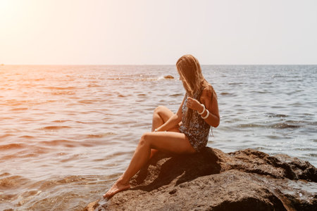 Woman summer travel sea. Happy tourist enjoy taking picture outdoors for memories. Woman traveler posing on the beach at sea surrounded by volcanic mountains, sharing travel adventure journeyの写真素材