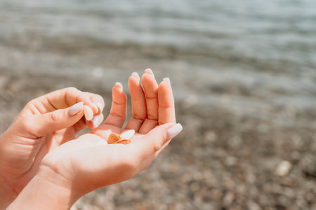 Woman eating milky almond nuts. A young caucasian woman chopping fresh green almond after morning fitness yoga near sea. Only hands are visibly. Healthy vegan food. Slow motion. Close upの写真素材
