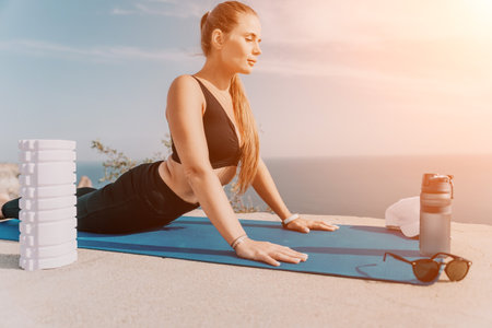 Fitness woman sea. Outdoor workout on yoga mat roller in park near to ocean beach. Female fitness...