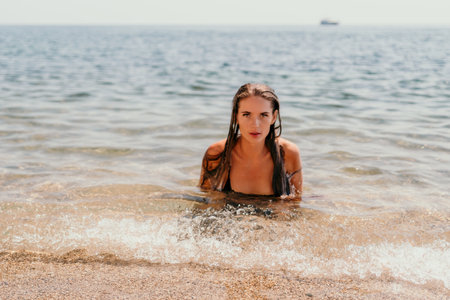 Woman summer travel sea. Happy tourist enjoy taking picture outdoors for memories. Woman traveler posing on the beach at sea surrounded by volcanic mountains, sharing travel adventure journeyの写真素材