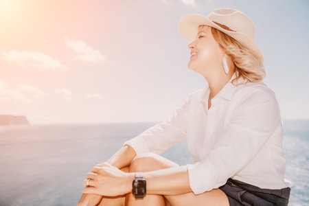 Woman sea laptop. Business woman in yellow hat freelancer with laptop working over blue sea beach. Girl relieves stress from work. Freelance, digital nomad, travel and holidays conceptの写真素材
