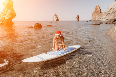 Woman sea sup. Close up portrait of happy young caucasian woman with long hair in Santa hat looking...