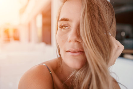 Happy woman portrait in cafe. Boho chic fashion style. Outdoor photo of young happy woman with long hair, sunny weather outdoors sitting in modern cafe.の写真素材
