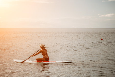 Woman in red bikini on sup board. Happy lady with blond hair in red bathing suit chilling and...