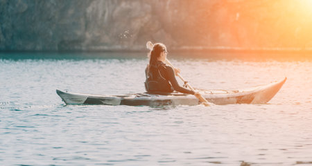Woman sea kayak. Happy smiling woman in kayak on ocean, paddling with wooden oar. Calm sea water and...