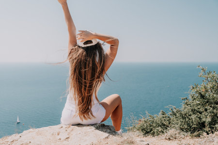 Woman travel sea. Young Happy woman in a long red dress posing on a beach near the sea on background of volcanic rocks, like in Iceland, sharing travel adventure journeyの写真素材