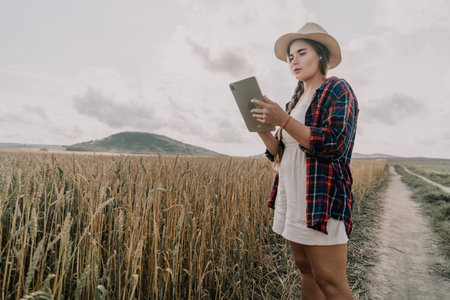 Woman wheat field. Agronomist, Woman farmer check golden ripe barley spikes in cultivated field....