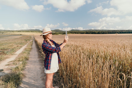 Woman wheat field. Agronomist, Woman farmer check golden ripe barley spikes in cultivated field. Closeup of female hand on plantation in agricultural crop management concept. Slow motionの写真素材