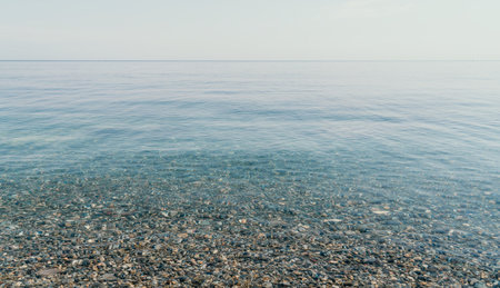 A calm body of water with a few rocks scattered throughoutの写真素材