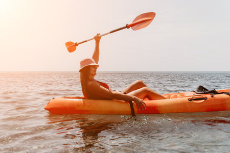 Woman sea kayak. Happy smiling woman paddling in kayak on ocean. Calm sea water and horizon in background. Active lifestyle at sea. Summer vacation.の写真素材
