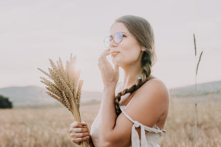 Woman wheat field. Agronomist, Woman farmer check golden ripe barley spikes in cultivated field. A...