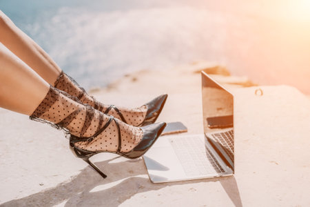 Woman sea laptop. Business woman in yellow hat freelancer with laptop working over blue sea beach....