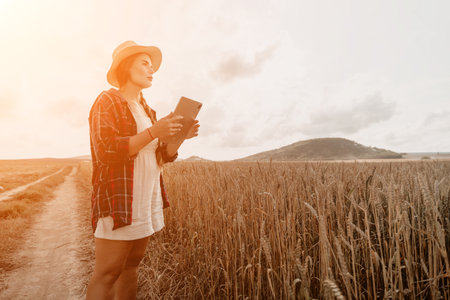 Woman wheat field. Agronomist, Woman farmer check golden ripe barley spikes in cultivated field. Closeup of female hand on plantation in agricultural crop management concept. Slow motionの写真素材