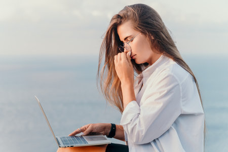 Woman sea laptop. Business woman, freelancer with laptop working over blue sea beach. Happy smiling...