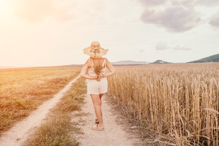 Woman wheat field. Agronomist, Woman farmer check golden ripe barley spikes in cultivated field. A woman is holding a bunch of wheat in her arms.の写真素材
