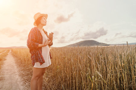 Woman wheat field. Agronomist, Woman farmer check golden ripe barley spikes in cultivated field. Closeup of female hand on plantation in agricultural crop management concept. Slow motionの写真素材