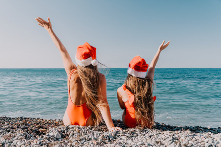Christmas on the Beach: A Festive Duo in Santa Hatsの写真素材