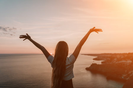 Silhouette of a Woman with Arms Raised at Sunset