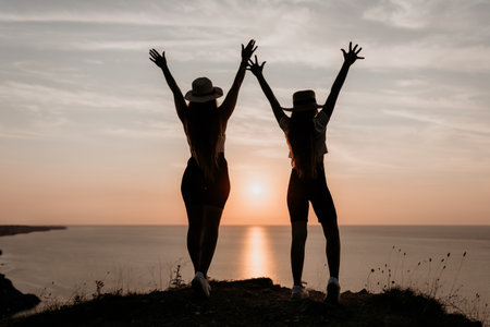 Silhouettes of Two Women Celebrating Sunset