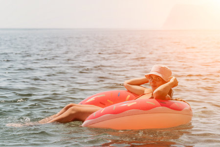 Summer Vacation Woman floats on an inflatable donut mattress, a water toy swim ring. Positive happy...