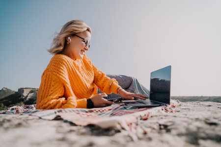 Smiling Woman Working on a Laptop Outdoorsの写真素材