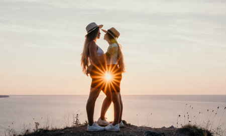 Silhouettes of Two Women Embracing at Sunsetの写真素材
