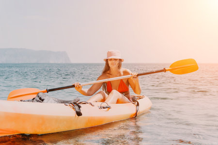 Woman sea kayak. Happy smiling woman paddling in kayak on ocean. Calm sea water and horizon in background. Active lifestyle at sea. Summer vacation.の写真素材