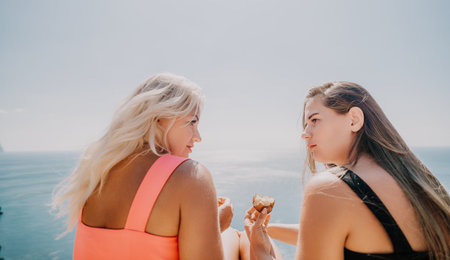 Two Women On A Cliff Overlooking The Sea