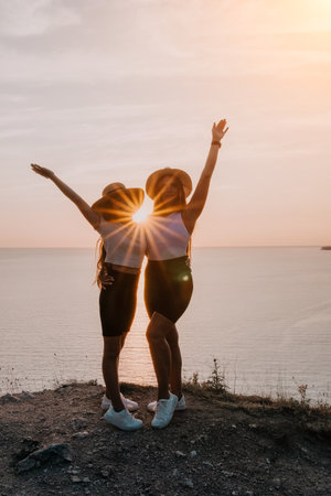 Two Women in Straw Hats Celebrate at Sunsetの写真素材