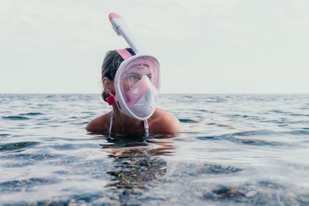 Young happy woman in white bikini and wearing pink mask gets ready for sea snorkeling. Positive...