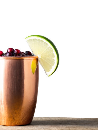 Cranberry Crush Vibrant red cocktail in a copper mug garnished with a lime wedgeの素材
