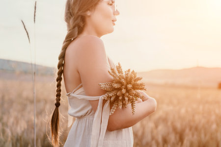 Woman wheat field. Agronomist, Woman farmer check golden ripe barley spikes in cultivated field. A...