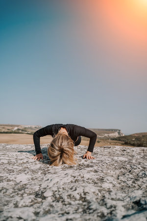 Woman Doing Push-Ups on a Rocky Clifftopの写真素材